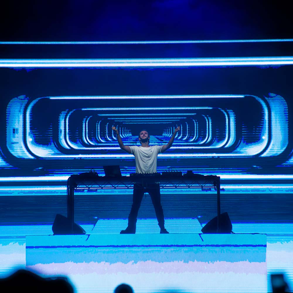DJ plays in front of large LED screen