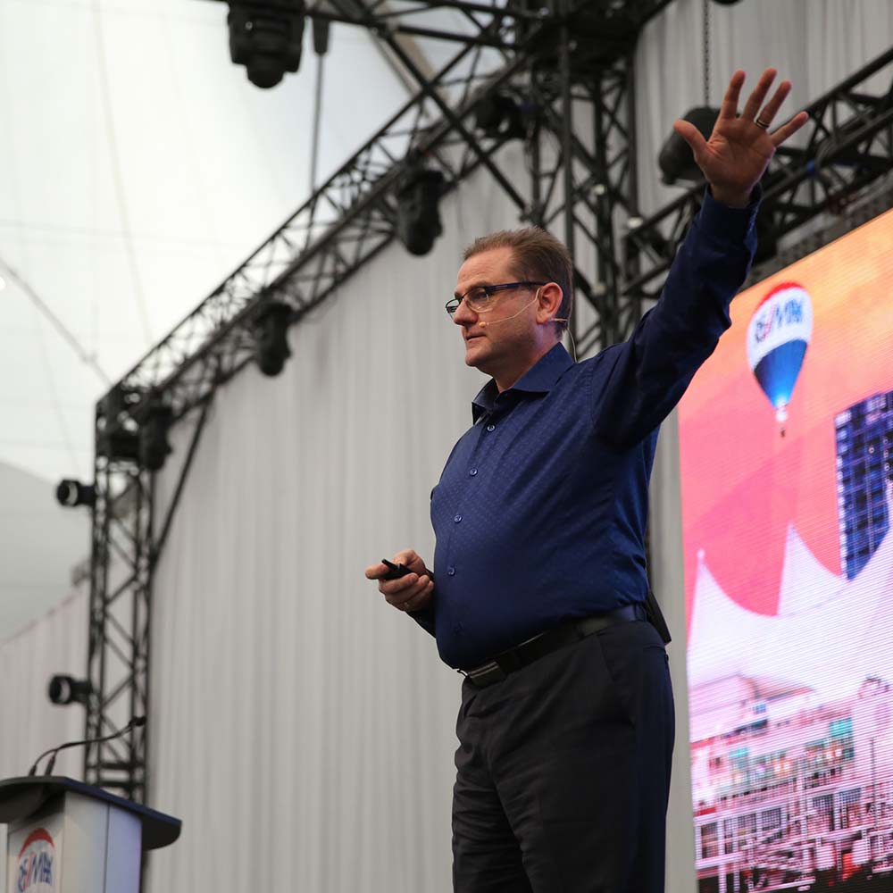 Speaker giving presentation on stage with headset microphone