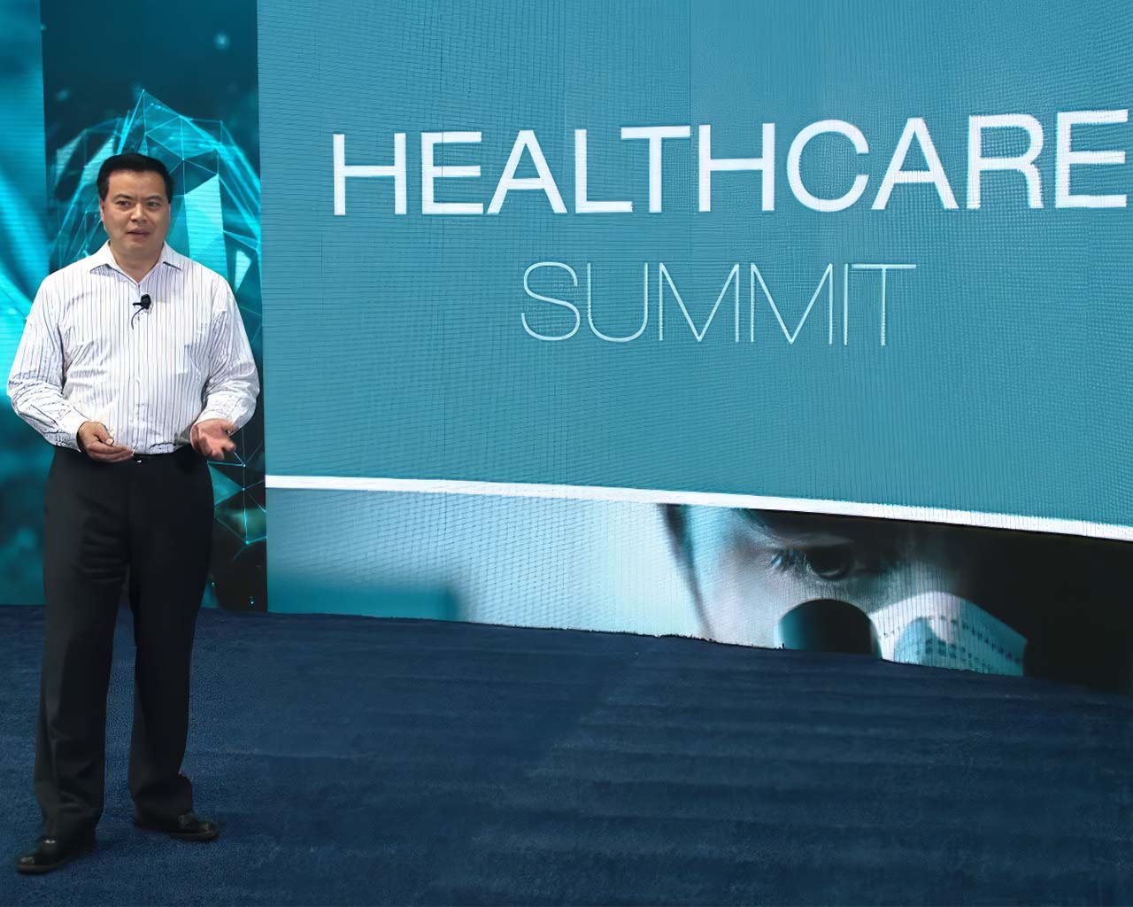 Host stands in front of LED screen at virtual event